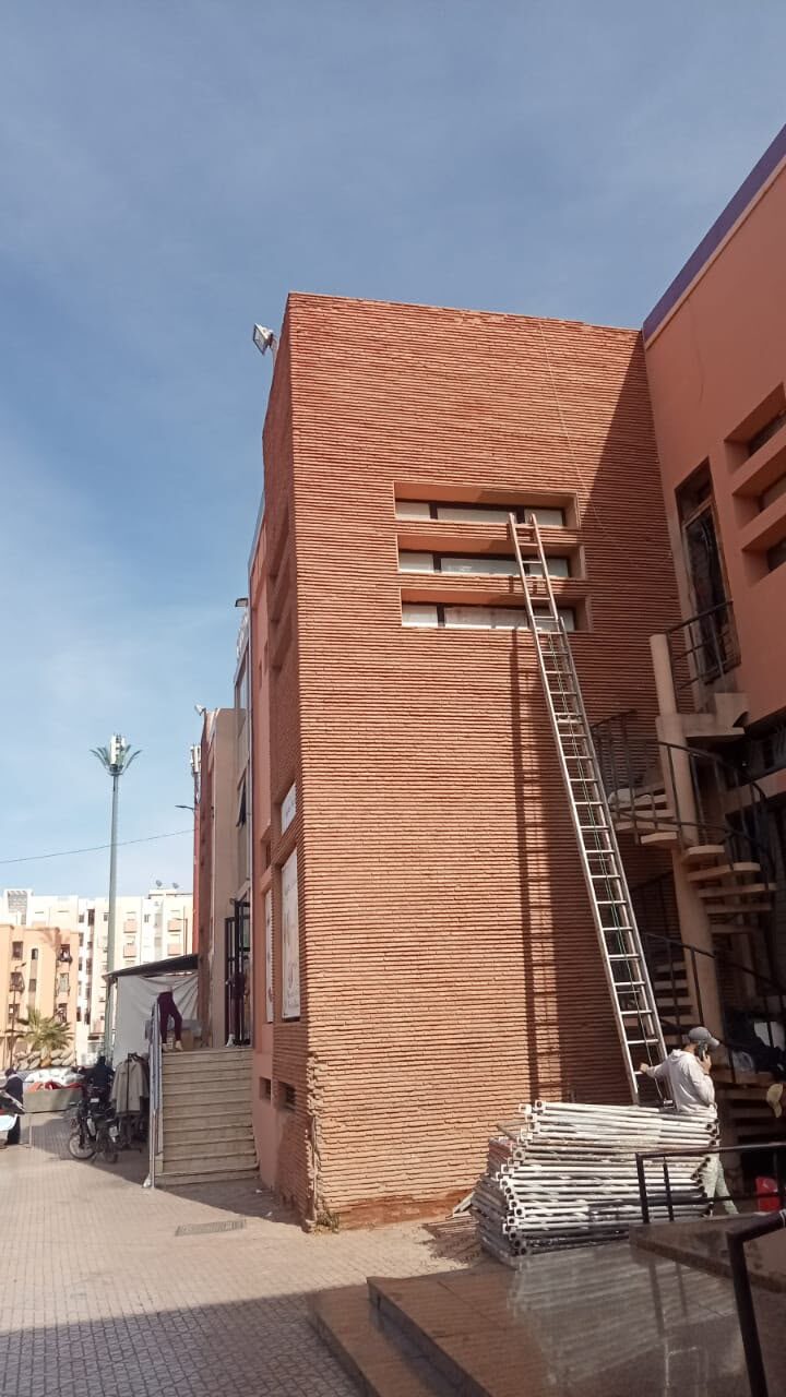 Façade en brique avec échelle et échafaudage